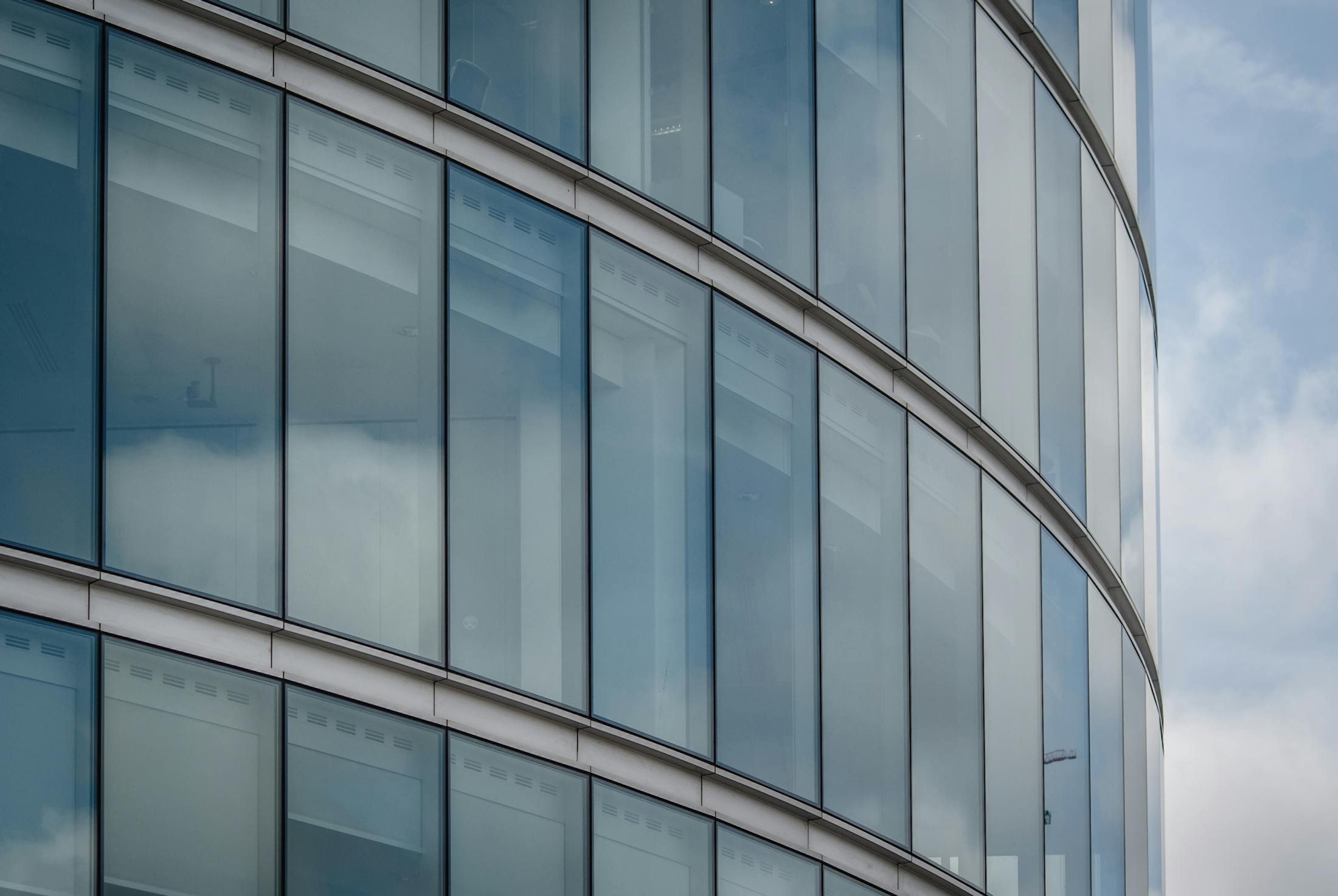Modern glass office facade with structured reflections